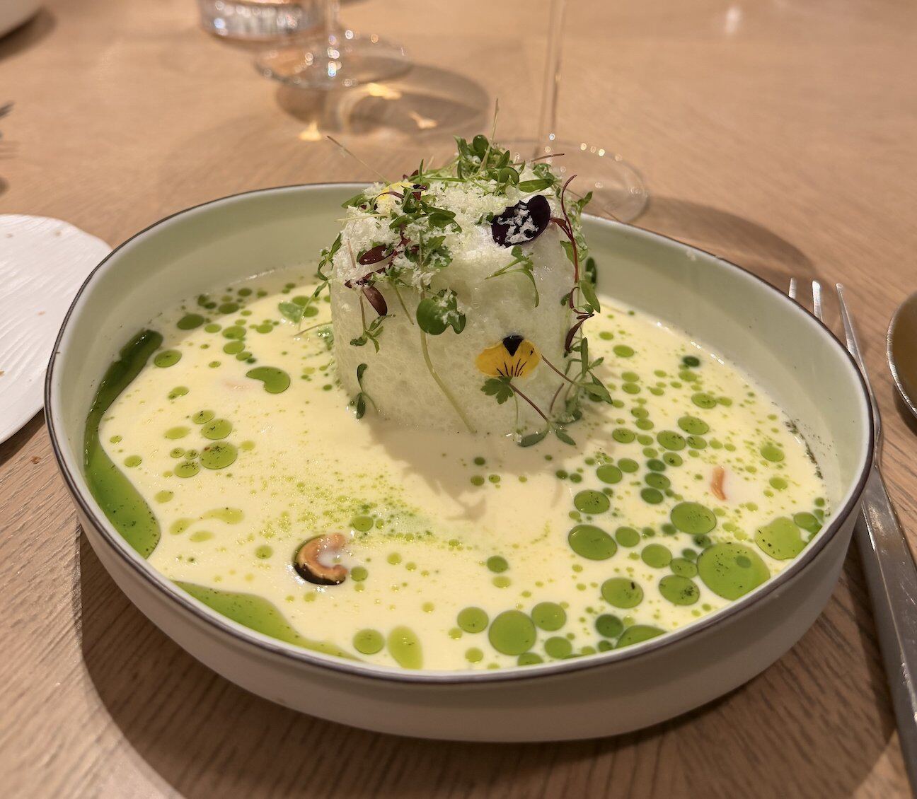 A plated dish garnished with microgreens and edible flowers